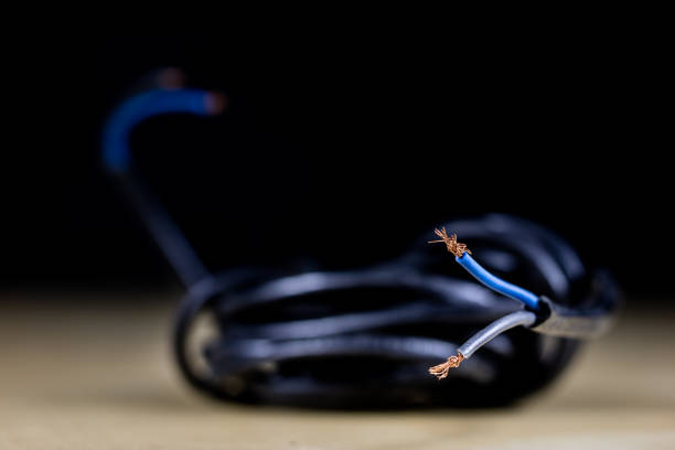 istock Electric cables, plugs and connectors on a wooden workshop table. Accessories and electrical components. Black background. 916414230