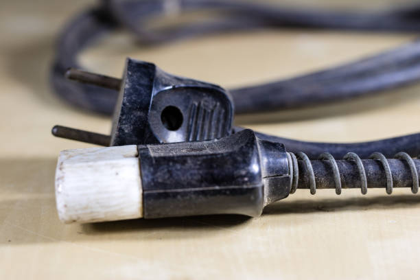 istock Electric cables, plugs and connectors on a wooden workshop table. Accessories and electrical components. Black background. 916414418