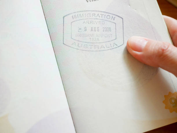 istock Hand holding passport with Australian immigration stamp 916414740
