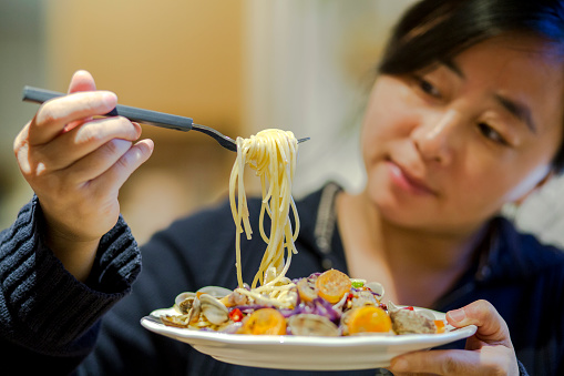 girl tasting seafood pasta
