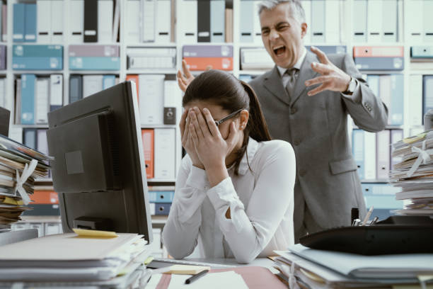 Angry boss yelling at his young employee Angry boss yelling at his young employee, she is stressed and feeling frustrated: bullying boss and mobbing concept chief leader photos stock pictures, royalty-free photos & images