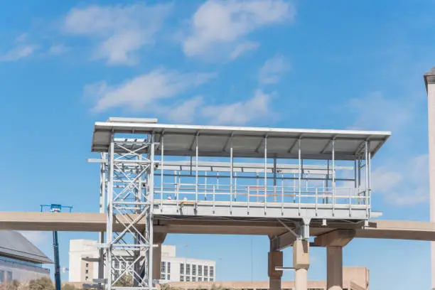 Light rail system station under construction in Las Colinas, Irving, Texas, USA. Elevated  Area Personal Transit (APT) automated peoplemover system platform blue sky.