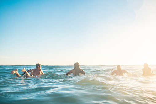 Friends preparing to surf in the ocean