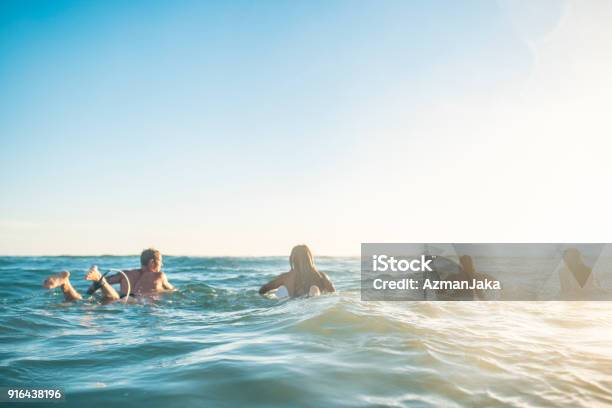 Friends Preparing To Surf In The Ocean Stock Photo - Download Image Now - Surfing, Beach, Swimming