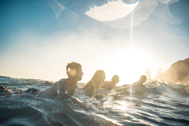 istock Friends swimming in the ocean with surfboards 916438206
