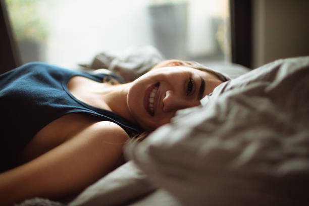 istock Young, smiling woman waking up 916448216