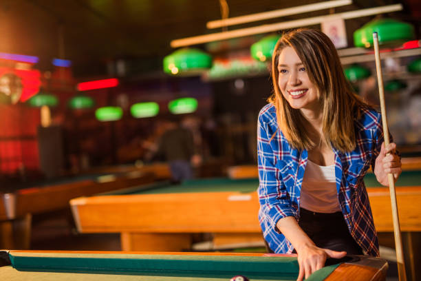 istock Happy young woman playing pool. 916461140