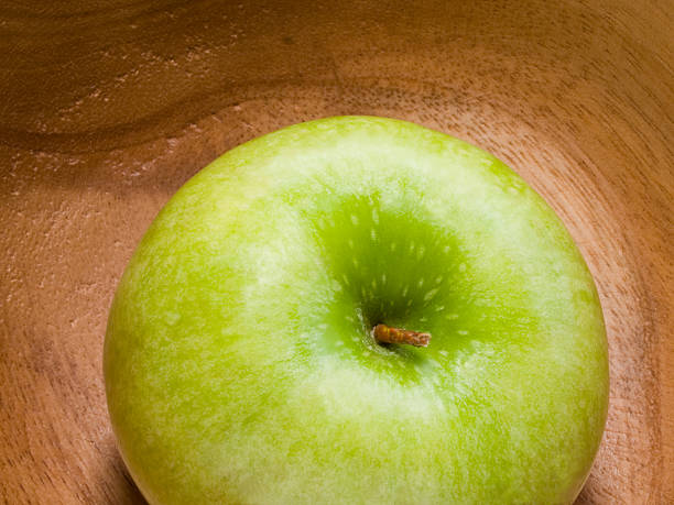 frais pomme verte sur la plaque en bois - food wood vibrant color close up photos et images de collection