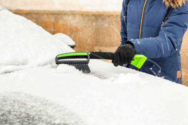 istock Woman removing snow from snow covered car in snowfall 916471538