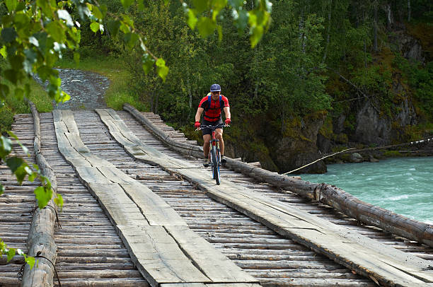 istock Mountain biker goes on old wooden bridge 91647515