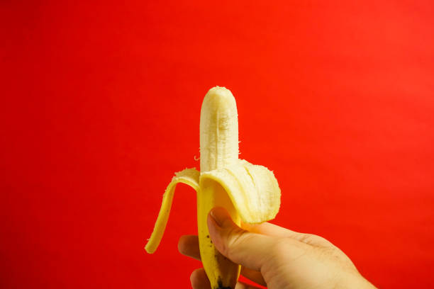 istock yellow banana, red background 916476056