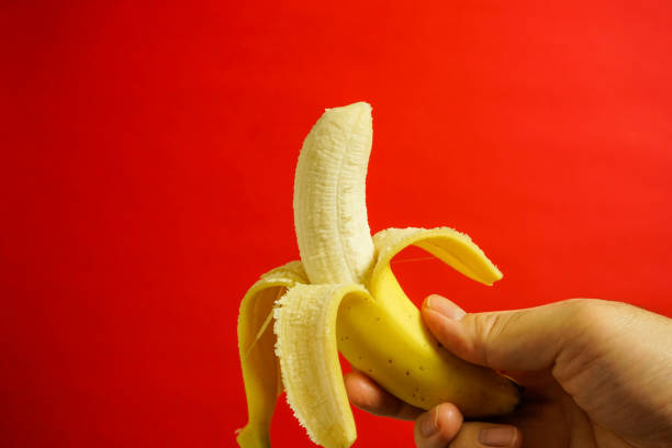 istock yellow banana, red background 916476060