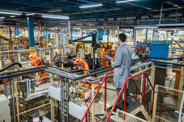Factory engineer inspecting the work process Male factory engineer inspecting the work process of the robots performing their operations in appliance manufacturing factory. robotics photos stock pictures, royalty-free photos & images