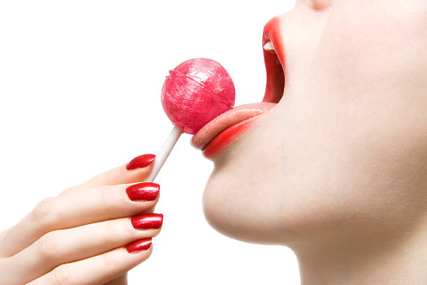 Woman licking sweet sugar candy closeup stock photo