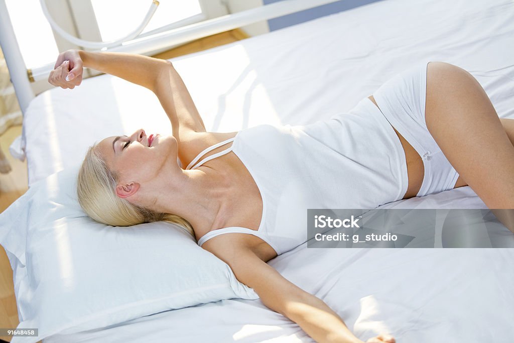 Foto de mujer joven hermosa en la cama en dormitorio - Foto de stock de Adulto libre de derechos