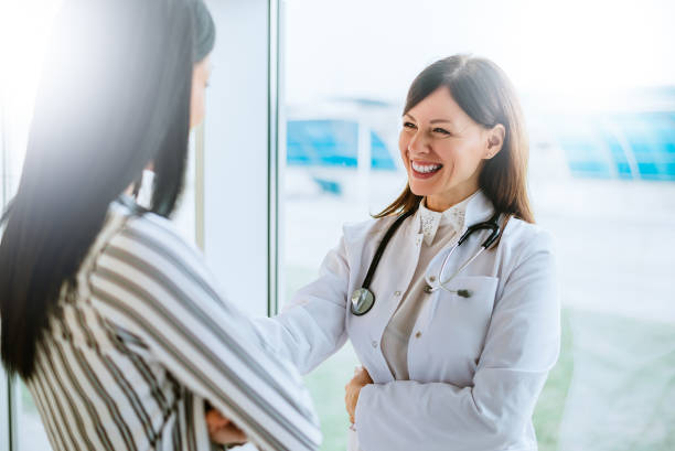 Cheerful doctor talking with her patient near window.