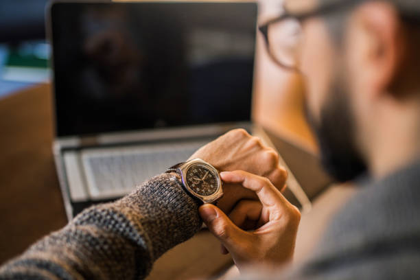 joven independiente control de tiempo de trabajo. - reloj de pulsera fotografías e imágenes de stock