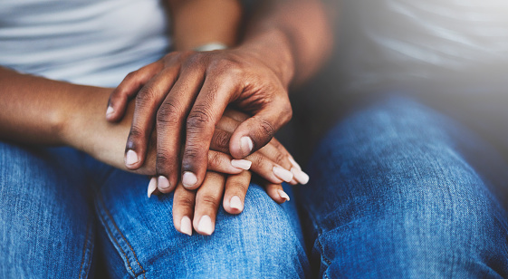 Closeup shot of an unrecognizable couple holding hands in comfort