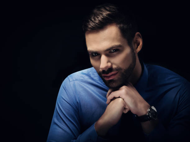 istock Young businesman portrait on black background 916493078