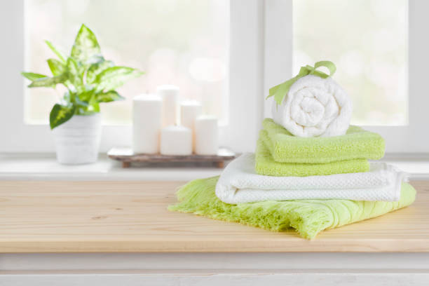 istock Spa towels on wooden table over blurred salon window background 916493306