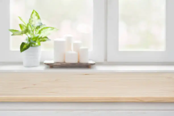 Photo of Wooden table over blurred window sill background for product display