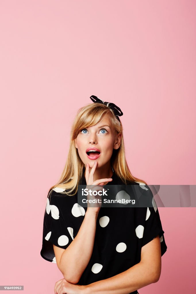 Inspired in spots Young woman in spotted clothing looking inspired Looking Up Stock Photo