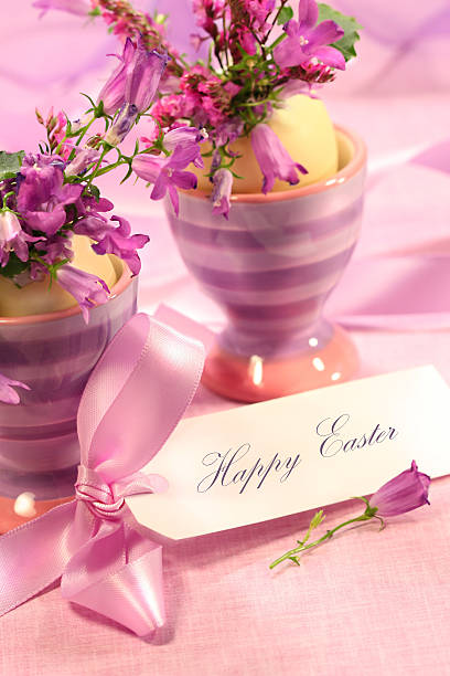 Purple flowers in eggs cups stock photo