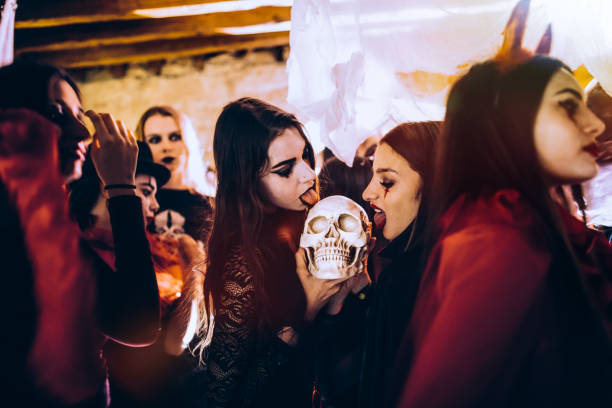 ハロウィーン パーティーで頭蓋骨を舐めている吸血鬼の衣装で若い女性 - women gothic style sensuality mystery ストックフォトと画像