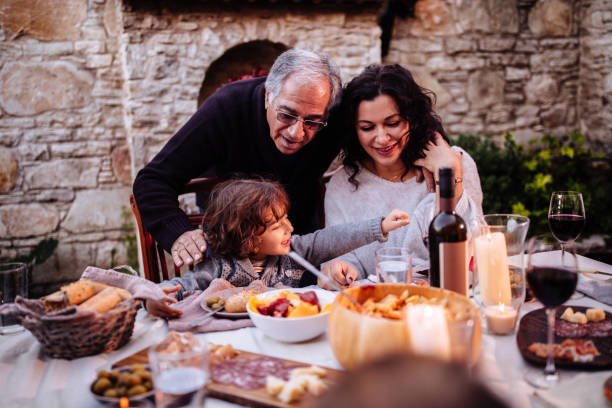 Happy young grandson having lunch at grandparents rustic house Happy grandson having Italian lunch with grandparents at traditional rustic restaurant in mediterranean village republic of cyprus photos stock pictures, royalty-free photos & images