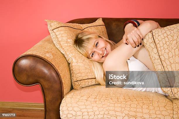 Jovem Mulher Em Um Sofá - Fotografias de stock e mais imagens de Aconchegante - Aconchegante, Adulto, Almofada - Artigo de Decoração