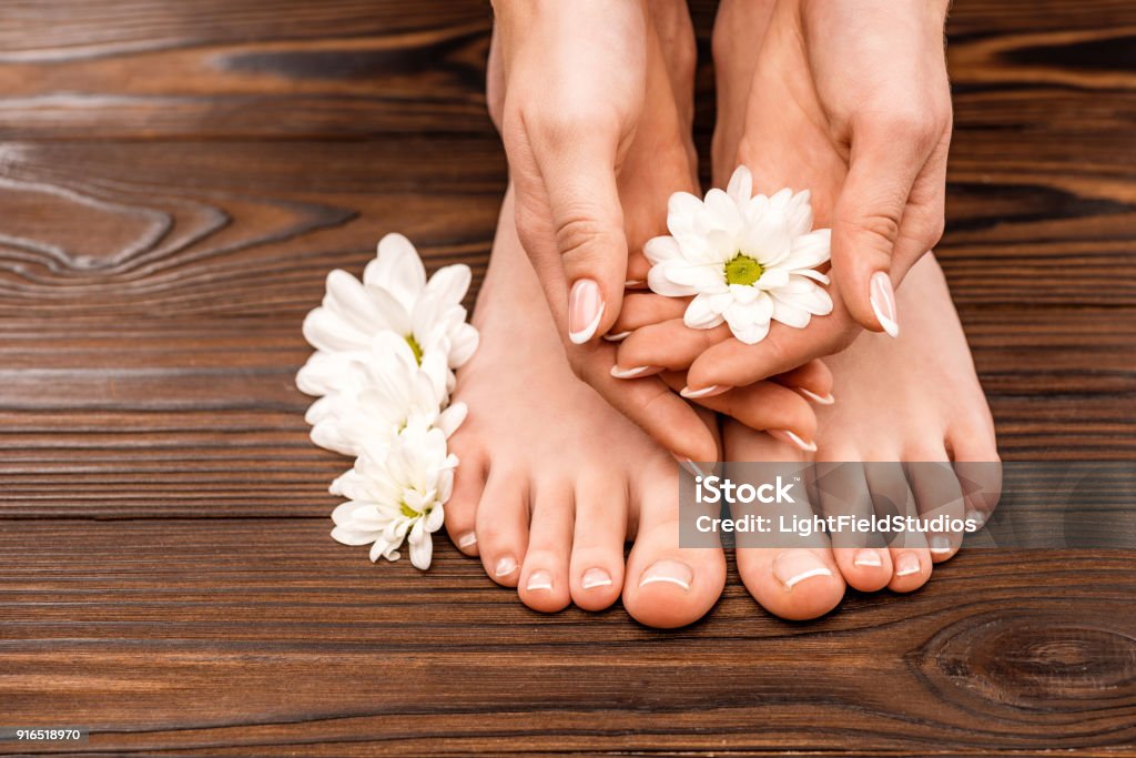 Blick auf weibliche Hände und Füße mit Medizin und Pediküre auf Holzoberfläche beschnitten - Lizenzfrei Fußpflege Stock-Foto