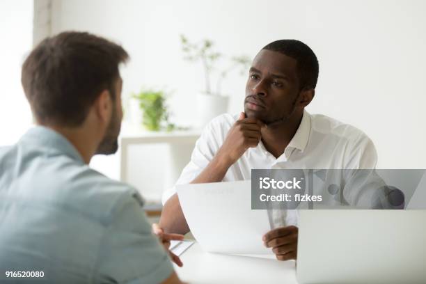 Serious Attentive African Hr Listening To Candidate At Job Interview Stock Photo - Download Image Now