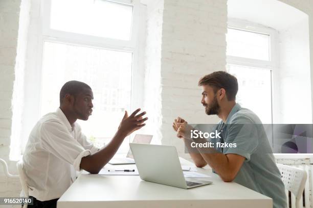 Africanamerican And Caucasian Colleagues Brainstorming New Startup Idea At Work Stock Photo - Download Image Now