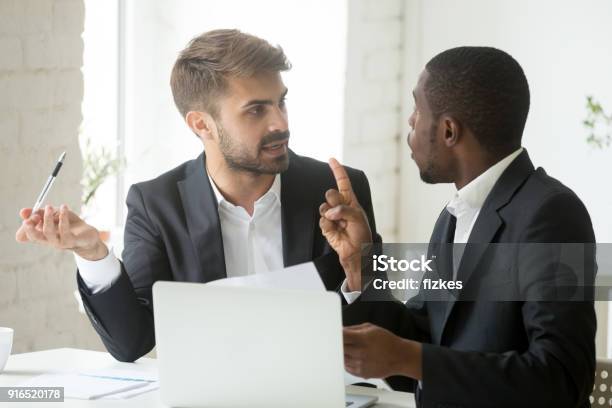 African Client Having Claims About Document Disagreeing With Caucasian Partner Stock Photo - Download Image Now