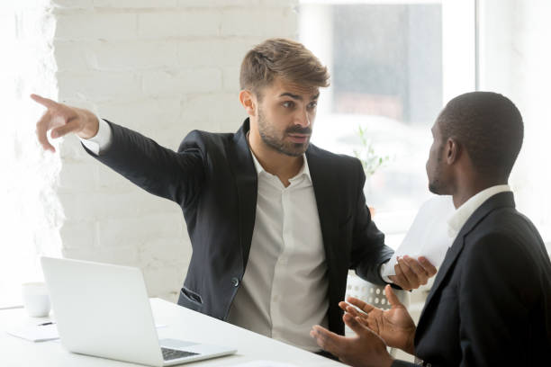 Rude white partner telling black businessman get out his office Angry rude caucasian executive firing male incompetent african employee for bad work, impolite white partner telling black businessman to get out detecting fraud, prejudice and racial discrimination evil corporation stock pictures, royalty-free photos & images