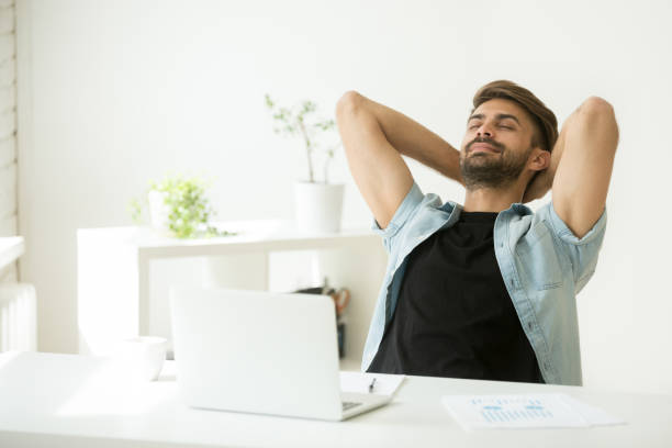 istock Relaxed man resting from work on laptop hand behind head 916520190