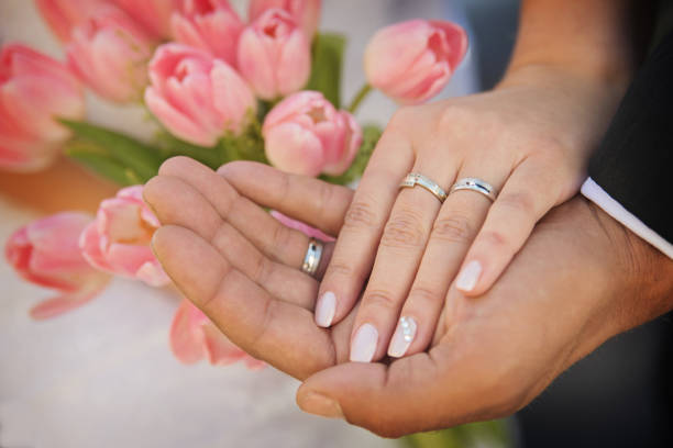 the hands of married couples and the wedding bouquet stock photo