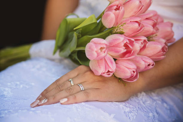 the hands of married couples and the wedding bouquet stock photo