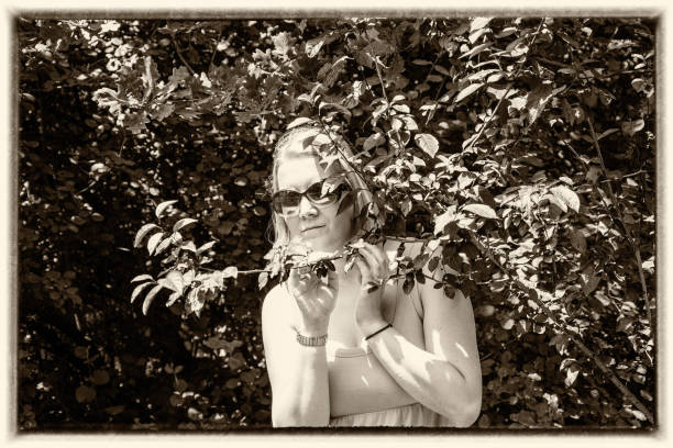 istock Blonde with sunglasses poses in nature 916522926