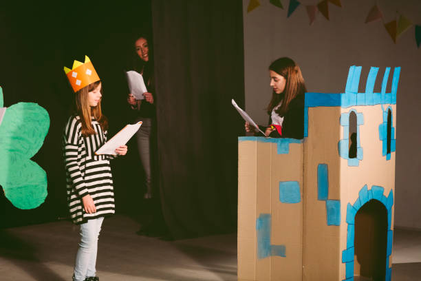 School Play Rehearsal Group of children enjoying drama club rehearsal. They are reading script with their drama teacher. playful set stock pictures, royalty-free photos & images