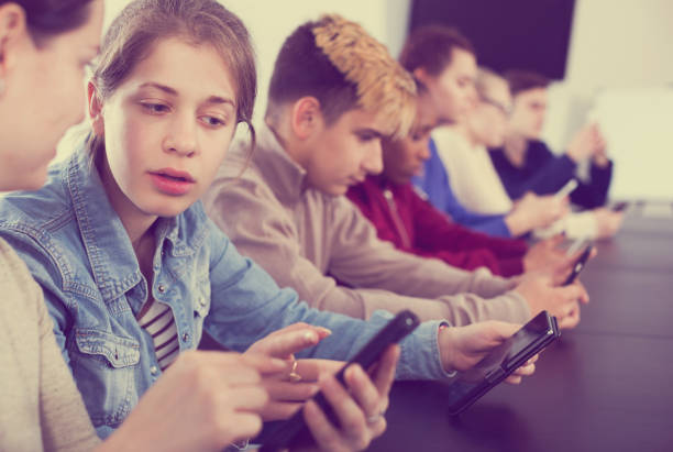 istock Male and female students playing with smartphones 916526680