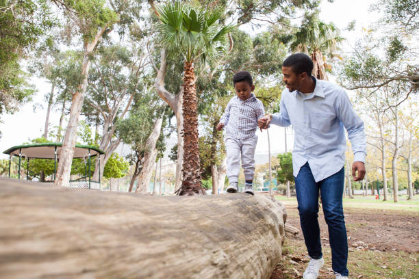 istock Dad walking his little boy along a log. 916537602