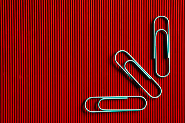 One red paper clip with red background.