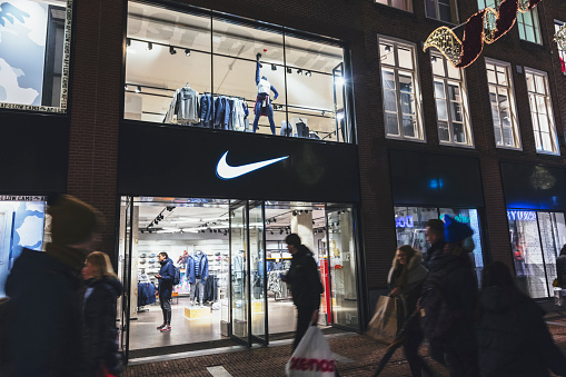 Amsterdam, Netherlands - December 15, 2017: People walks by Nike sports fashion store in Amsterdam, Netherlands. Nike brand was valued at 19 billion USD in 2014.
