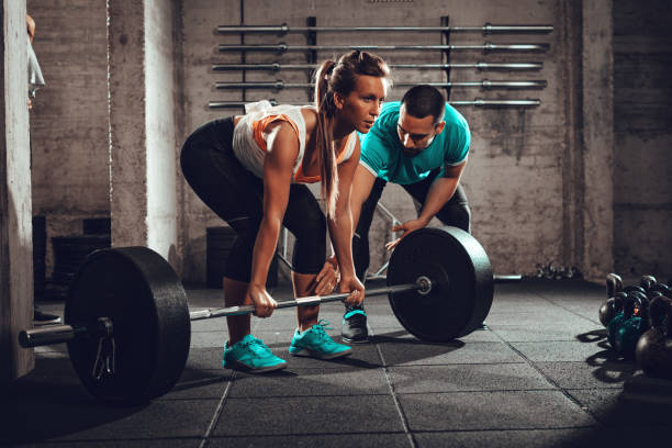 パーソナル トレーナーとトレーニング - weight training crouching barbell weightlifting ストックフォトと画像