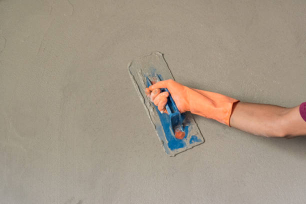 istock Leveling concrete with trowels, mason hands spreading poured concrete. Selective focus. 916551674