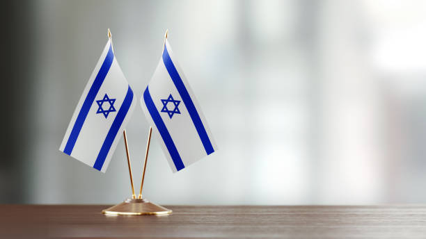 istock Israeli Flag Pair On A Desk Over Defocused Background 916556348