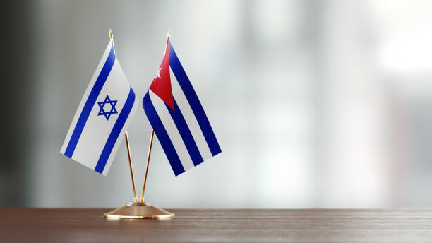 istock Cuban And Israeli Flag Pair On A Desk Over Defocused Background 916556762
