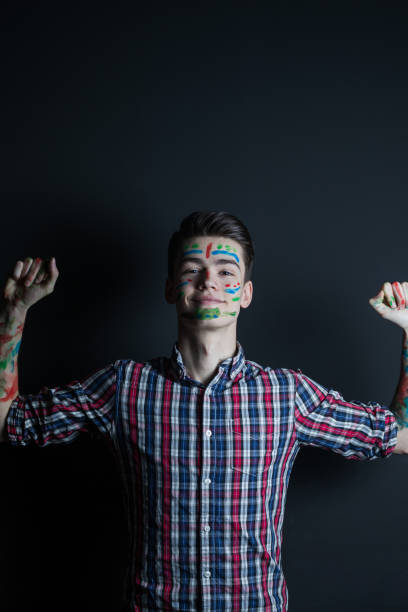 istock Playful young man with colored face 916572250