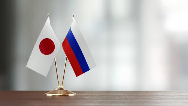 par de bandera japonesa y rusa en un escritorio sobre fondo defocused - japanese flag fotos fotografías e imágenes de stock